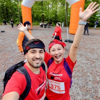 Traila team members celebrating at an outdoor charity fun run, wearing red team T-shirts.