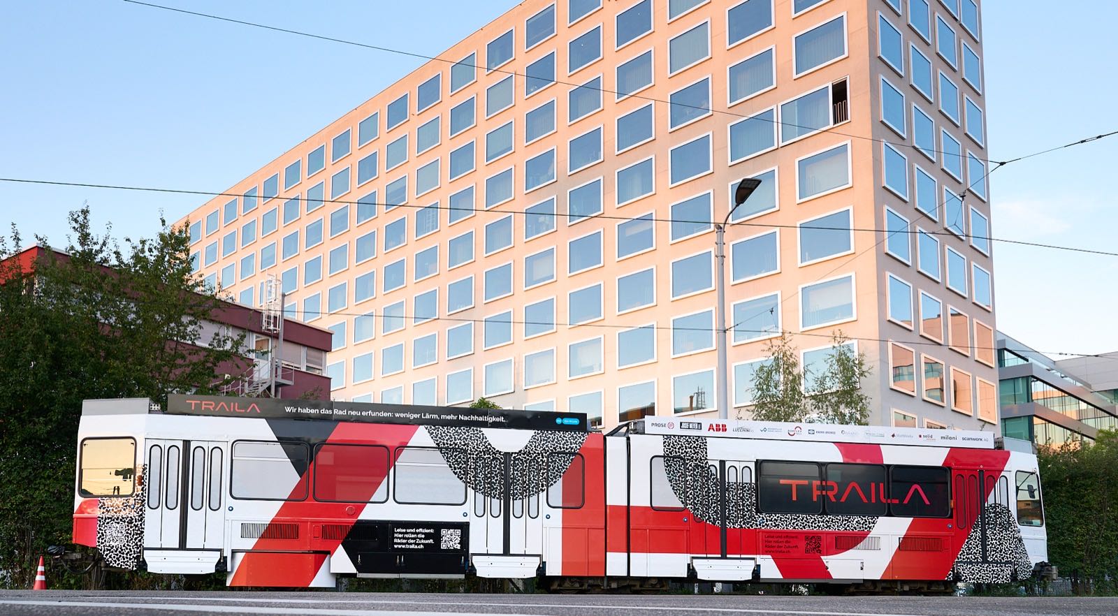 The TX4 test tram in Traila livery, a modified Tram 2000, standing on a street in front of an office building.